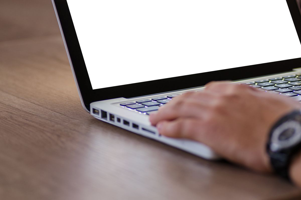 A person using a laptop on a desk, representing a patient trying to navigate a medical practice website