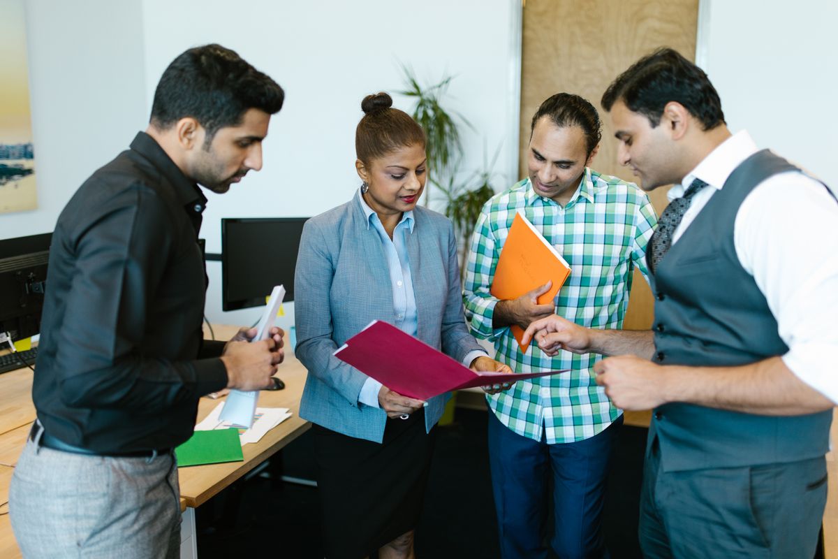 A team reviewing a printed document together, representing human oversight of AI generated healthcare content