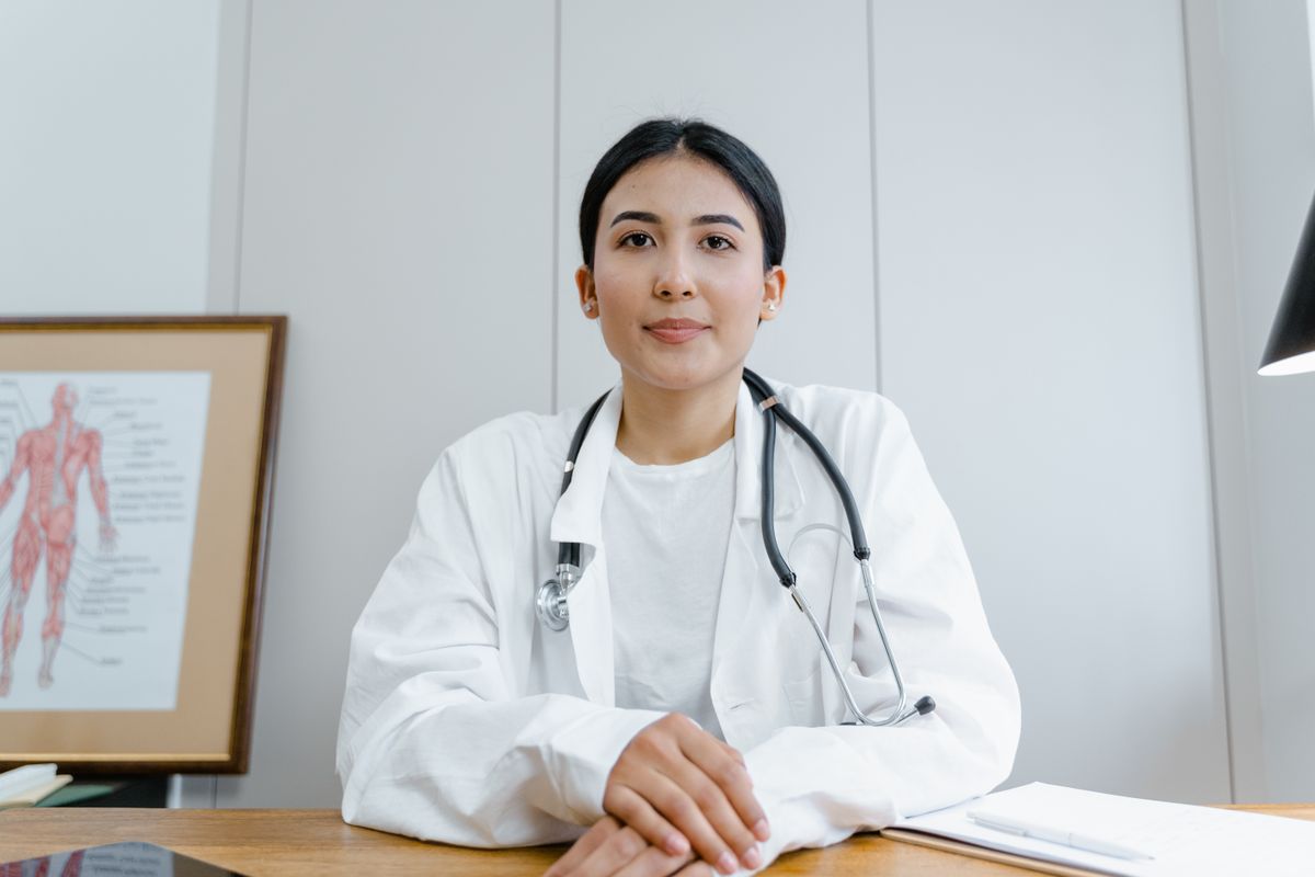 Doctor sitting at a desk facing the camera, representing patient trust and AI transparency in a medical practice