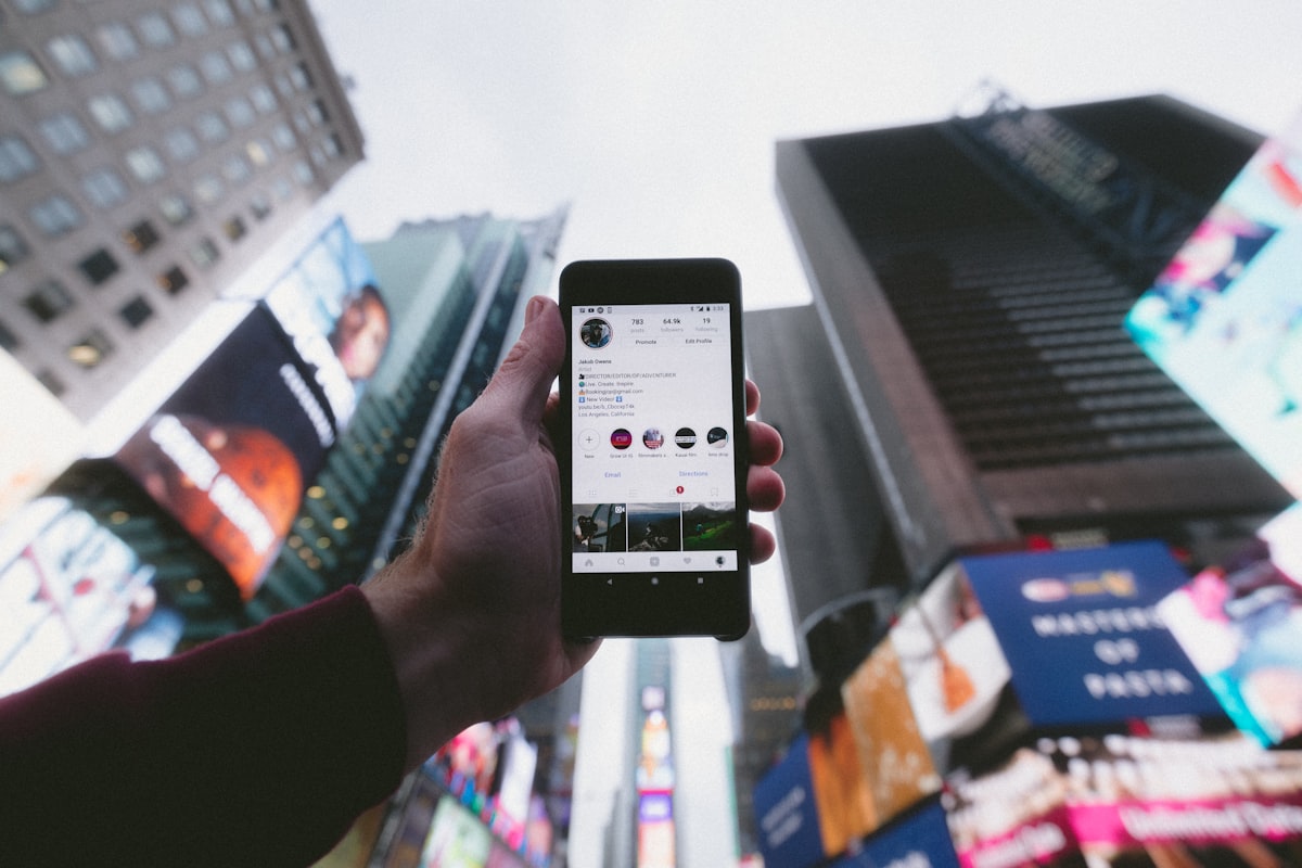 A patient holding up a phone in a city, researching a doctor online before booking an appointment