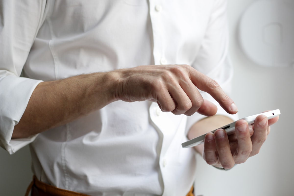 A person tapping a phone to ask a question about a medical practice on Google Maps