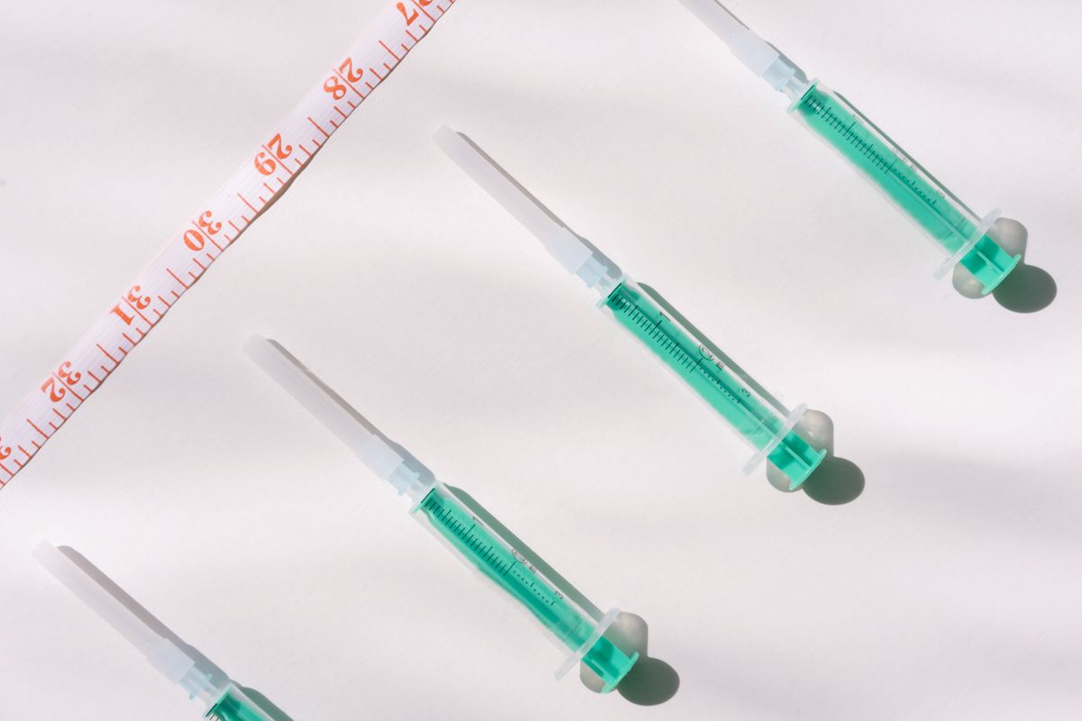 GLP-1 weight loss injection syringes next to a measuring tape, representing semaglutide and tirzepatide advertising rules