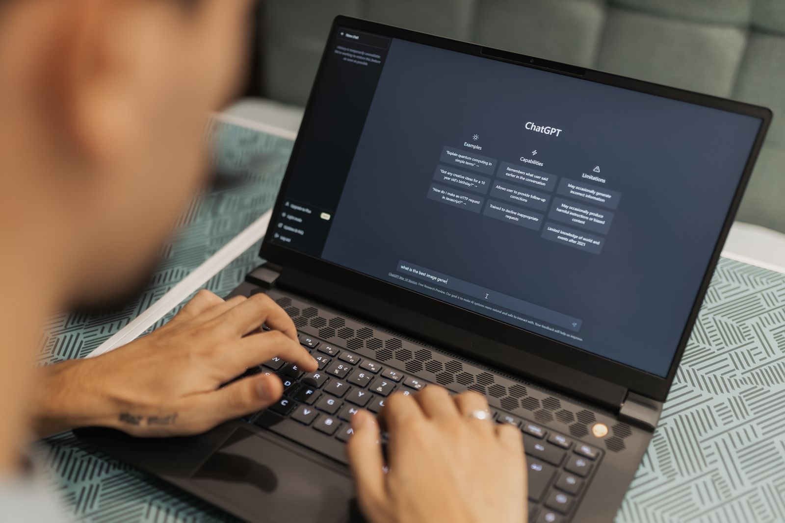 A person typing a question into ChatGPT on a laptop, the way many patients now research a doctor before booking