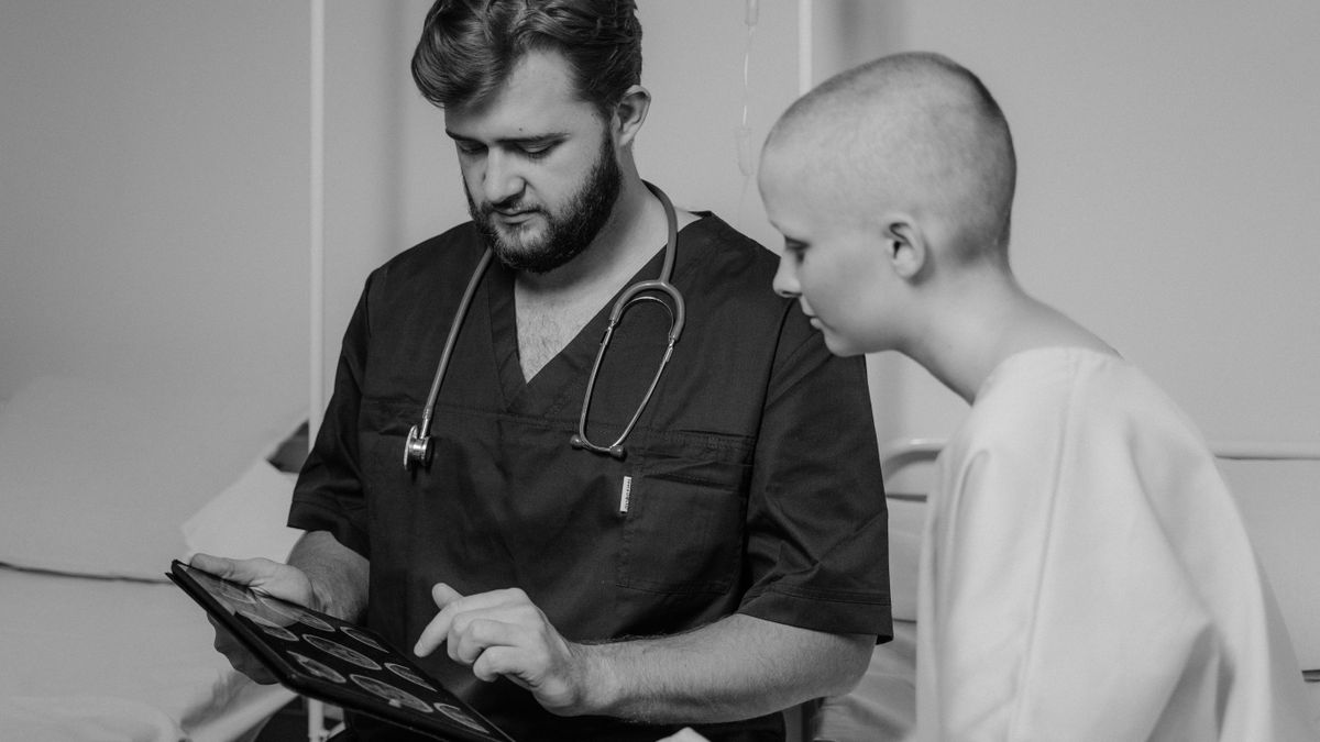 A patient and a doctor reviewing medical records together on a tablet during a visit