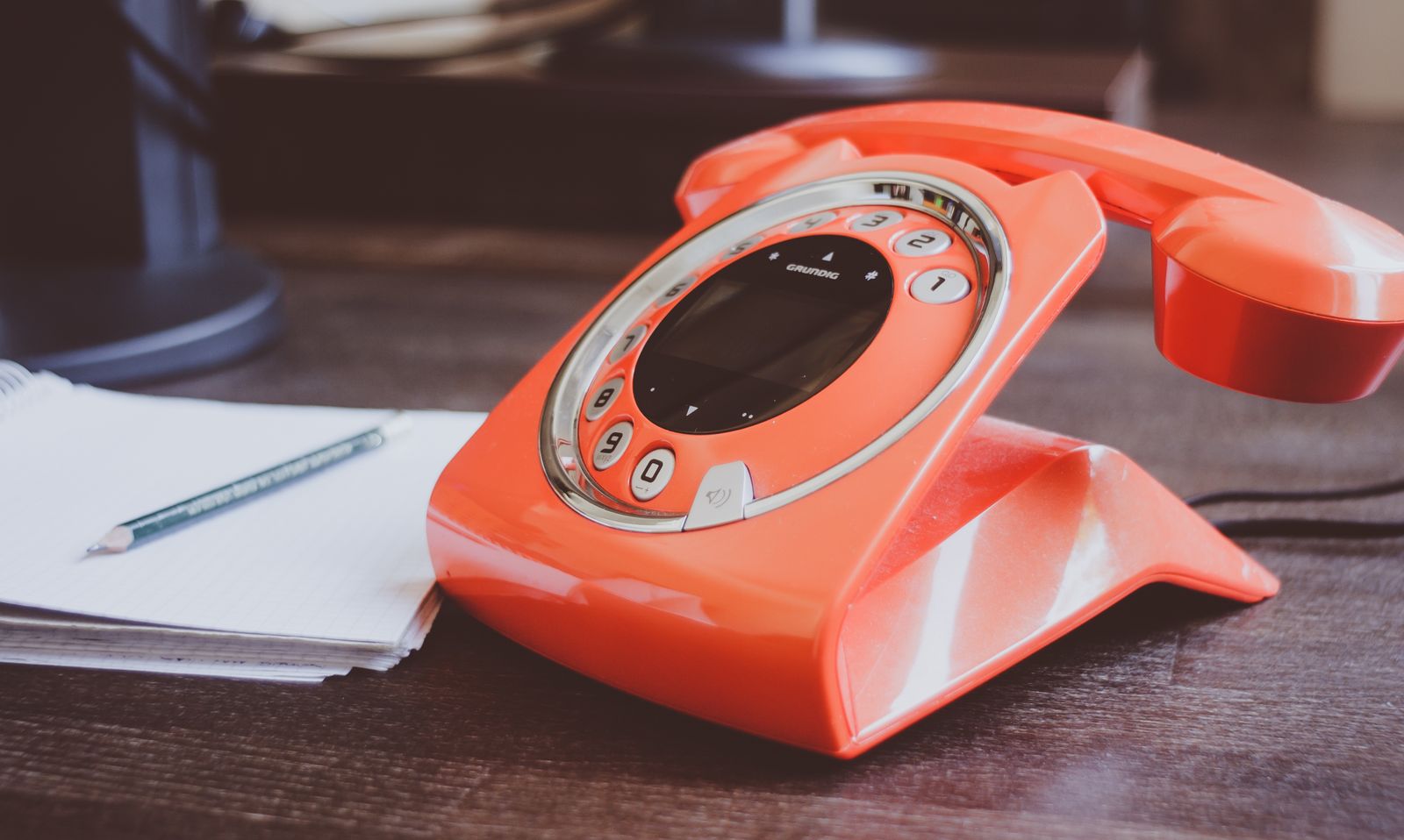 An office phone left off the hook next to a blank notepad, the patient call a busy front desk never got to