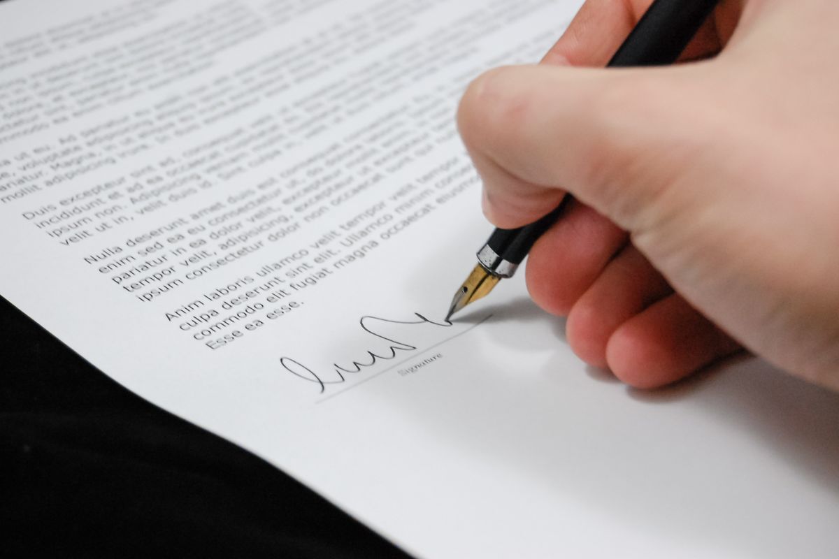 Two people signing a business associate agreement contract before a marketing agency handles patient data