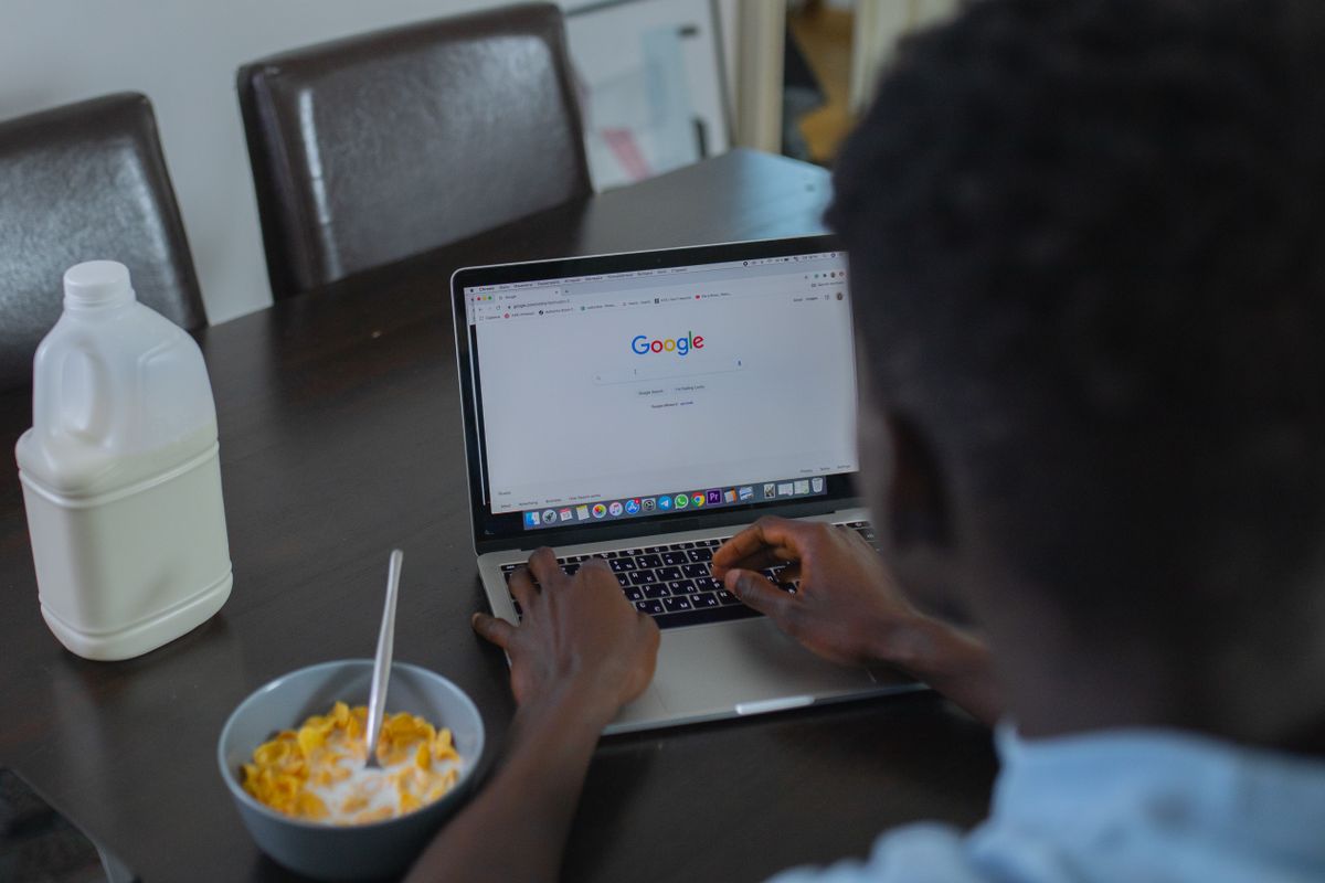 A patient searching Google on a laptop to find a doctor, the moment where trust in ads versus organic results decides who gets the booking