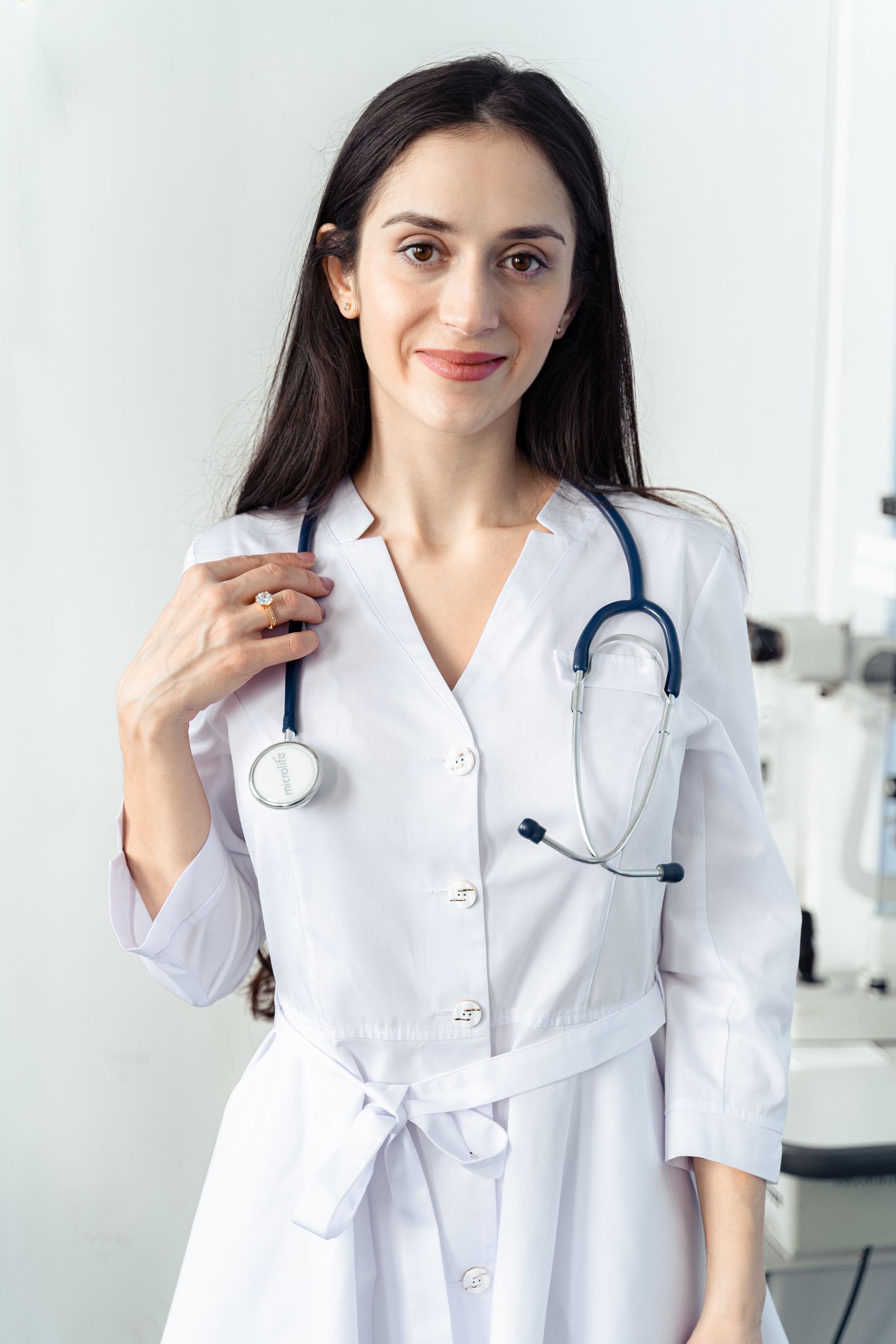 Friendly doctor in a white coat smiling at the camera, the kind of real face patients want to see and hear before booking a medical practice