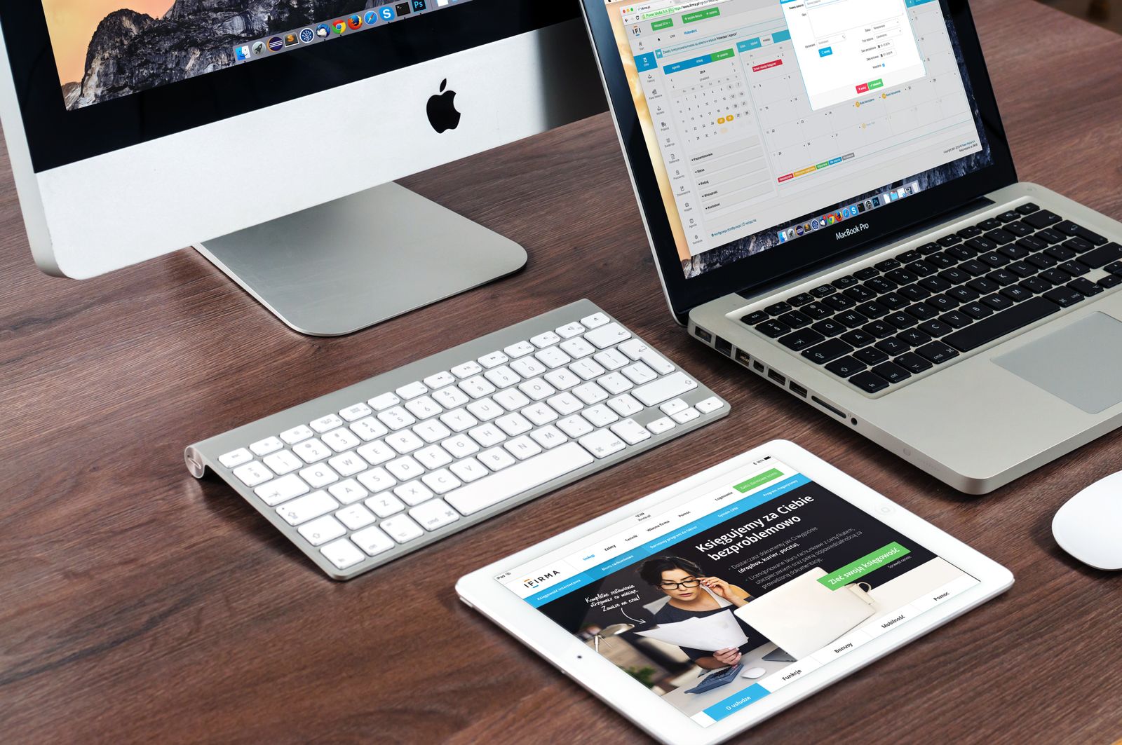 A desk with a computer, laptop, and tablet all showing a website, the digital assets a medical practice owner should actually own