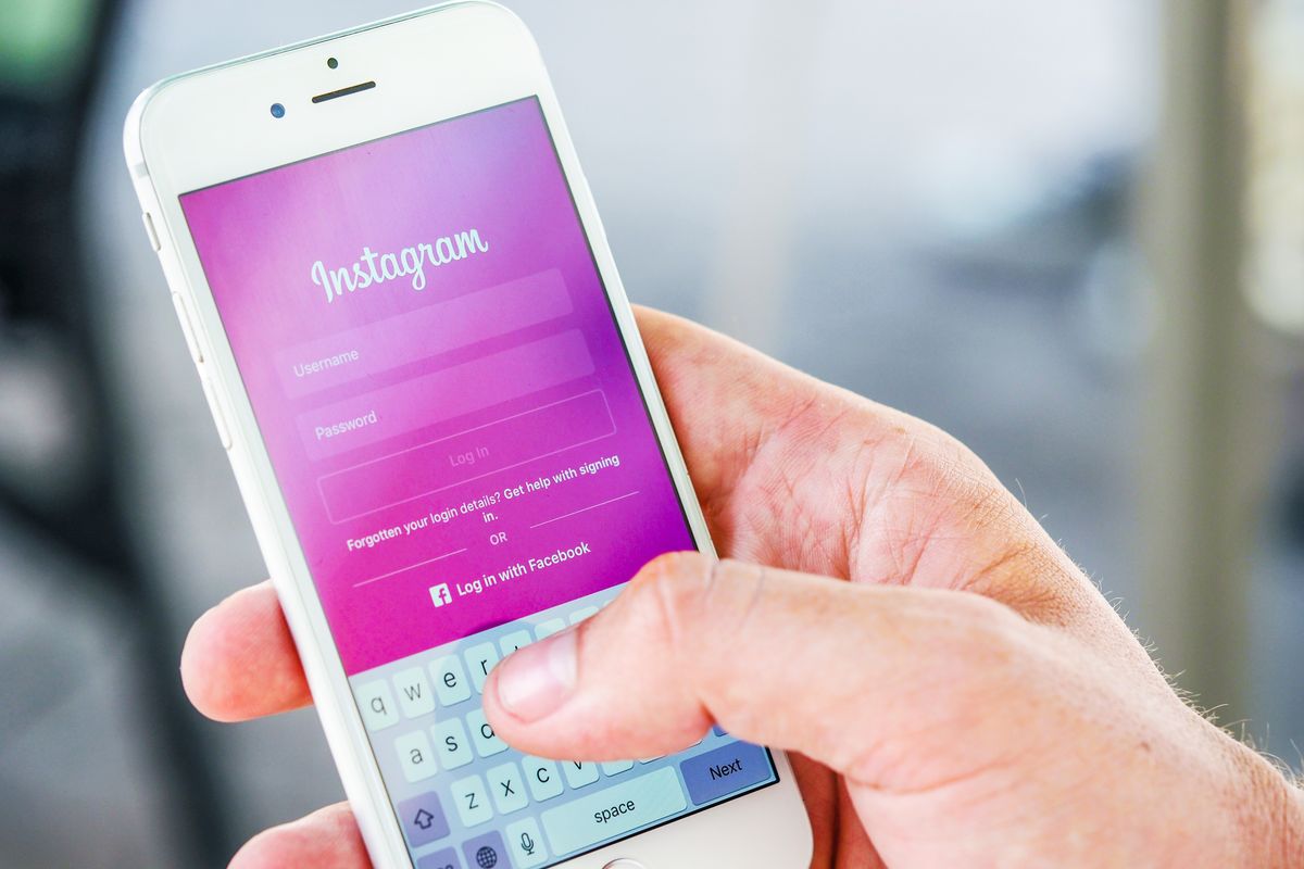 A person checking a medical practice social media page on a phone before booking an appointment