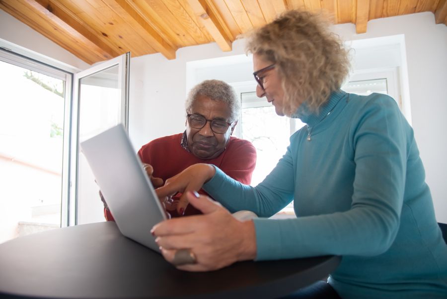 An older couple searching for a doctor together on a laptop, the kind of patient who often finds practices through Bing