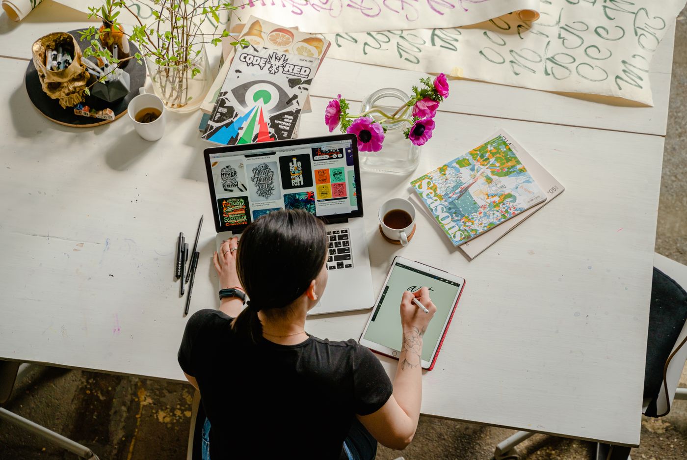Person writing blog content on a tablet next to a laptop, planning articles for a medical practice website