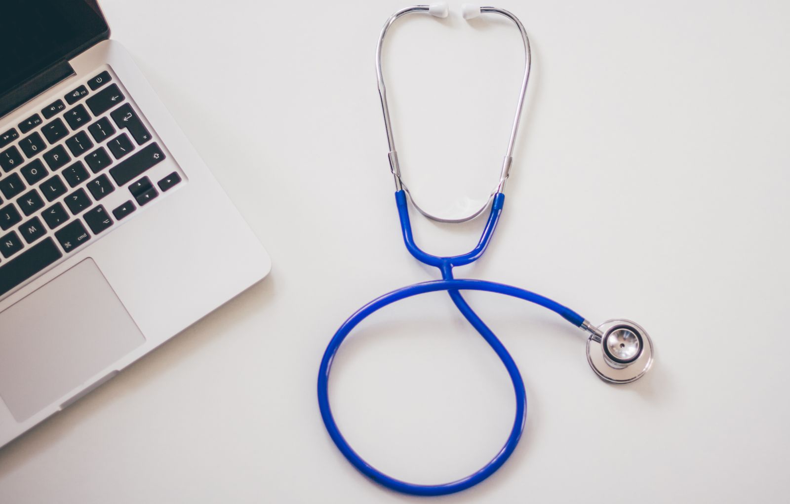 A stethoscope next to a laptop, representing a medical practice website being judged by Google
