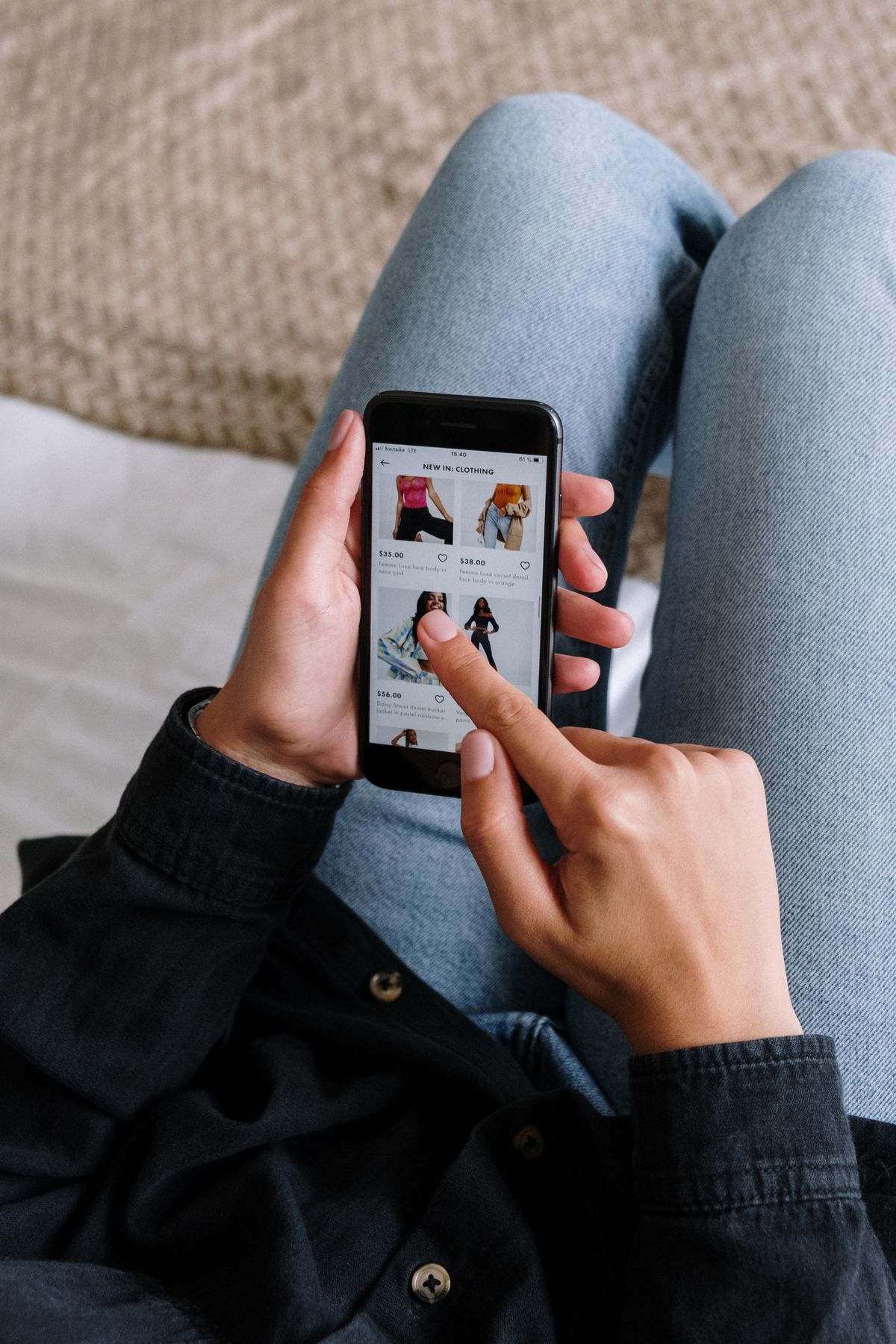 A person scrolling a social media shopping feed on a phone, the way patients discover an aesthetics or med spa practice through influencer content