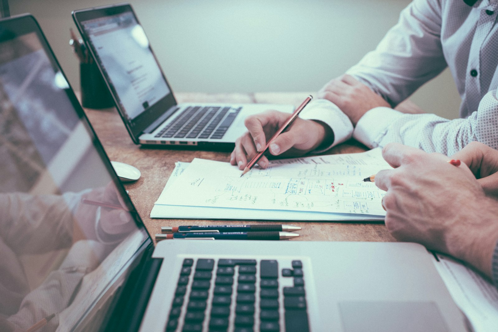 Two advisors reviewing business charts and plans at a desk, representing the valuation of a medical practice