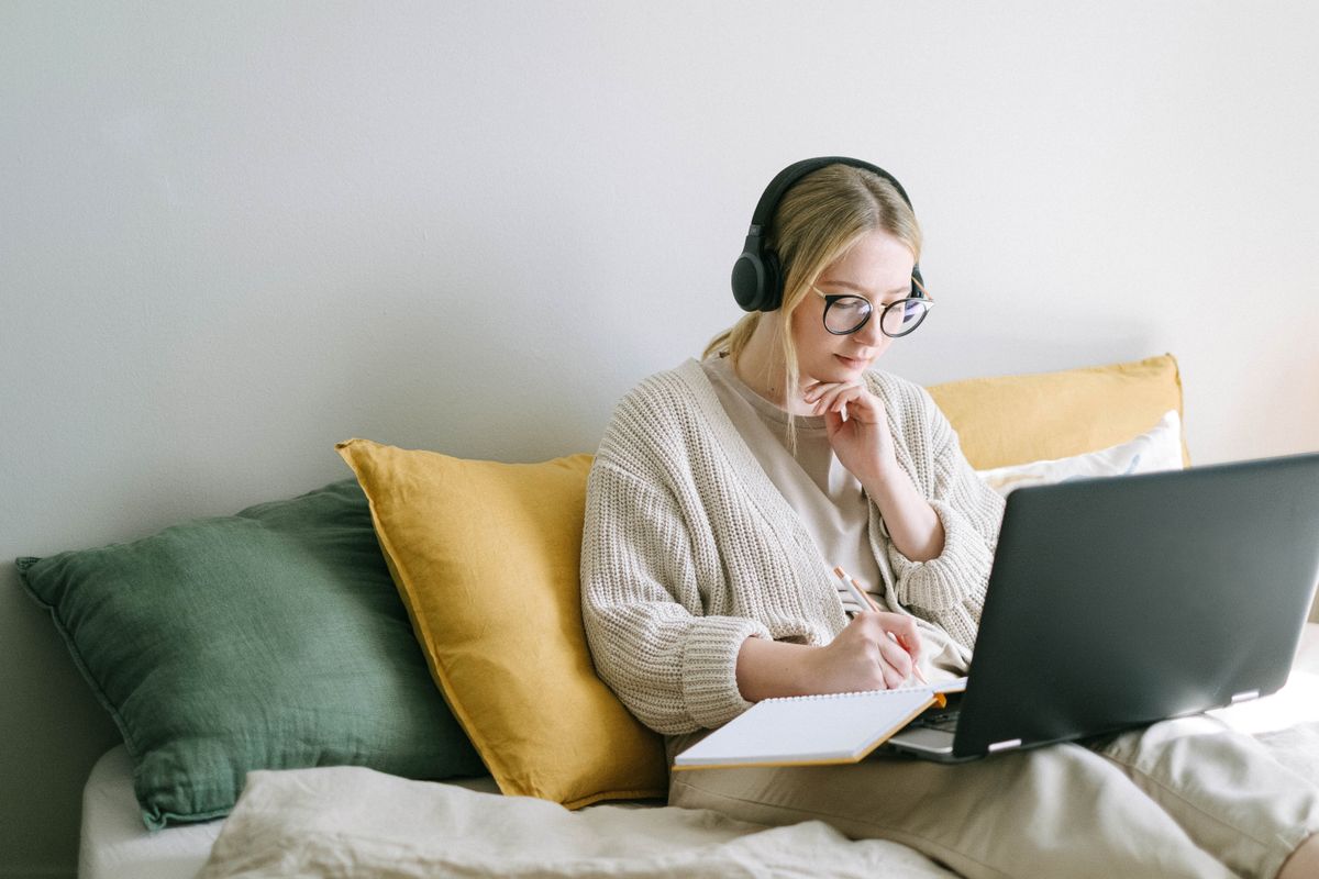 A woman reading a laptop screen, representing a patient reading a medical practice Google Business Profile description before booking