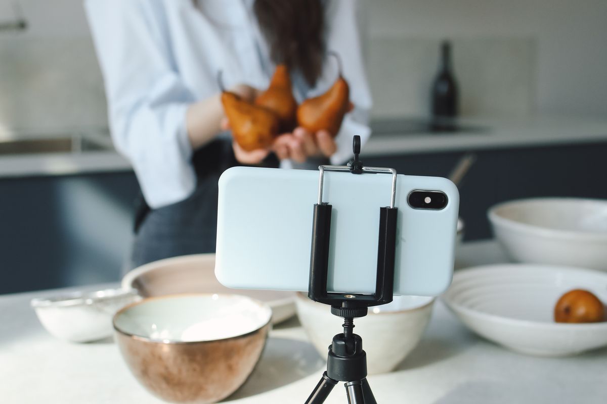 A person recording a short educational video on a phone mounted on a tripod, the kind of content a medical practice can make to teach patients