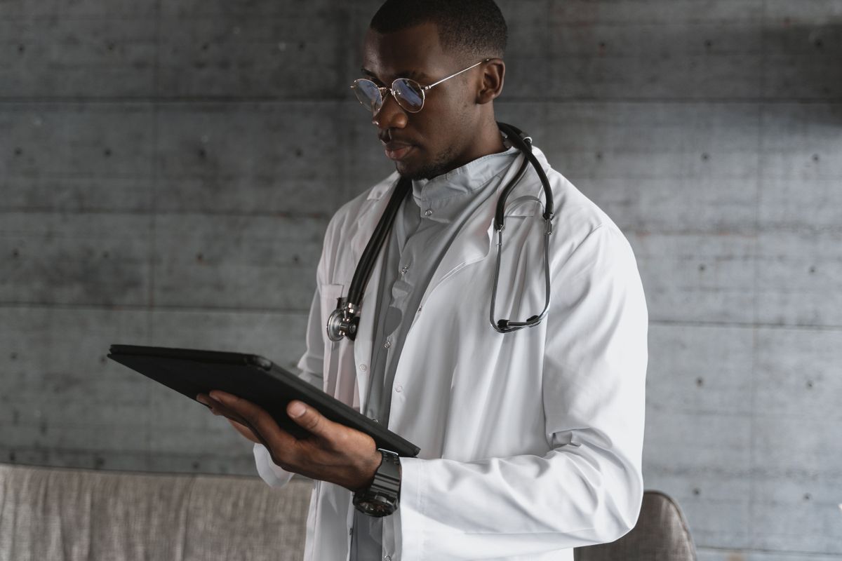 A doctor reviewing information on a tablet, representing AI in healthcare for independent medical practices