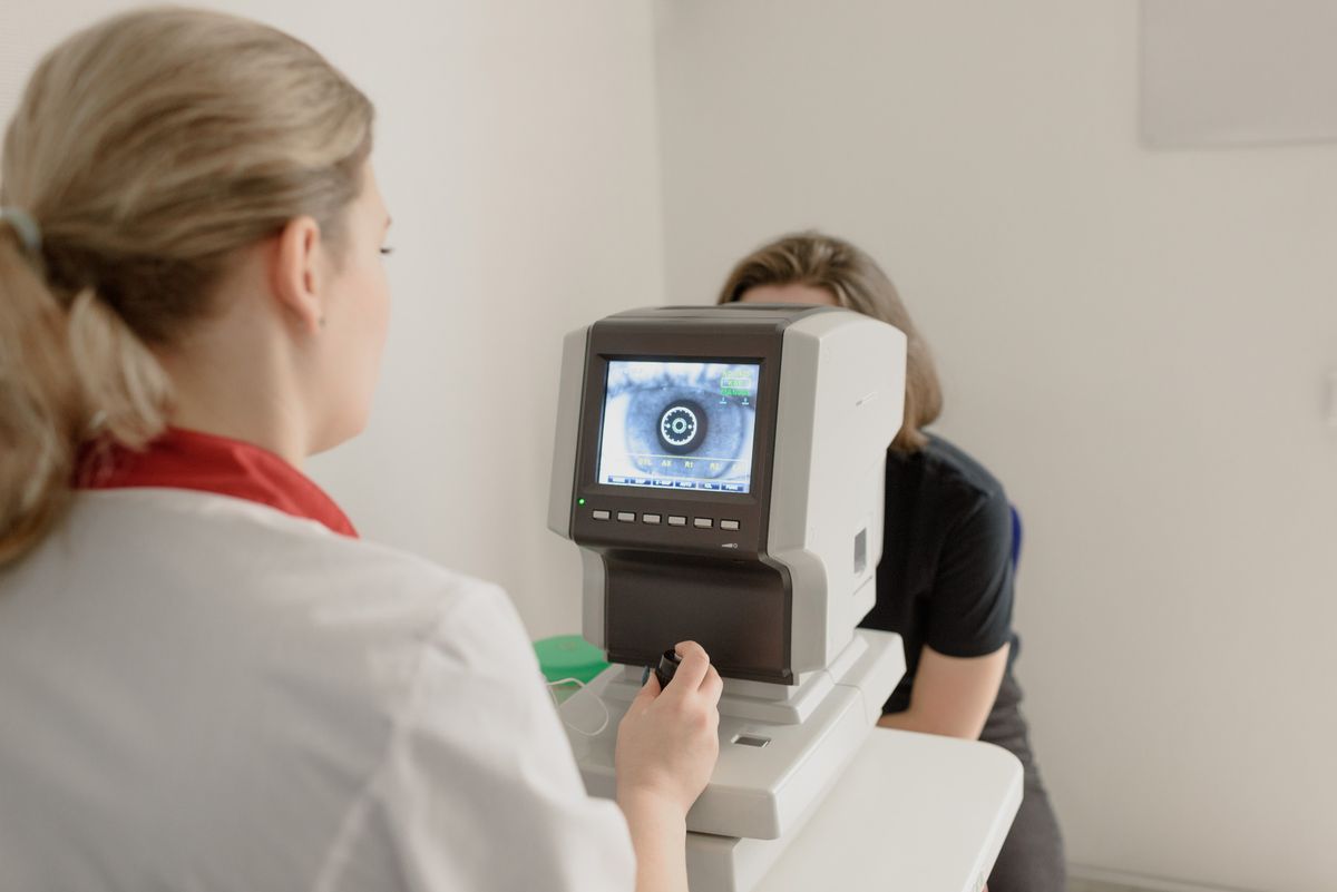 Optometry technician running an eye exam on a patient before year end vision benefits expire