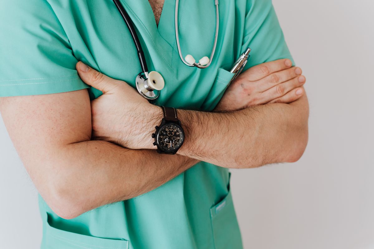 A healthcare provider in scrubs with a stethoscope, ready for fall flu shot season at a medical practice
