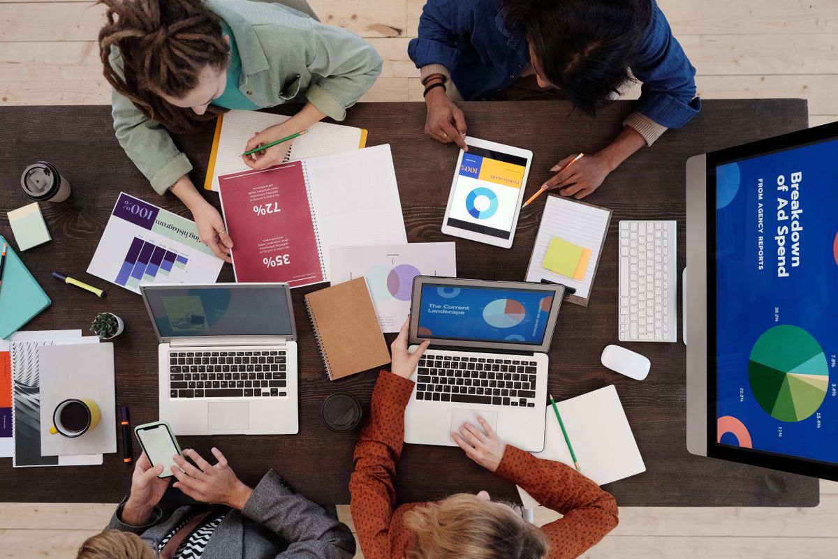 Marketing team reviewing an ad spend breakdown on laptops and a screen, illustrating how to set up Google Ads extensions for a medical practice