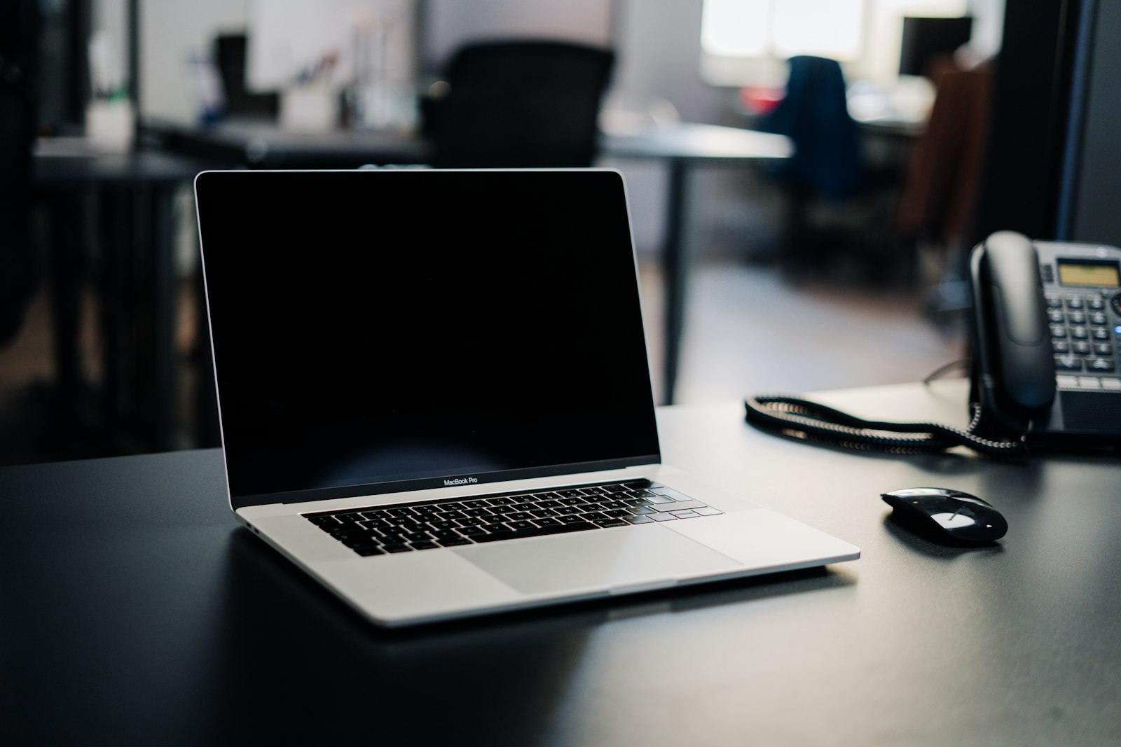 A laptop and an office desk phone side by side, the two paths a Google Ads click can take for a medical practice