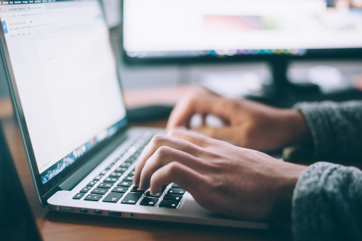 A medical practice owner at a laptop flagging a fake Google review from a person who was never a patient