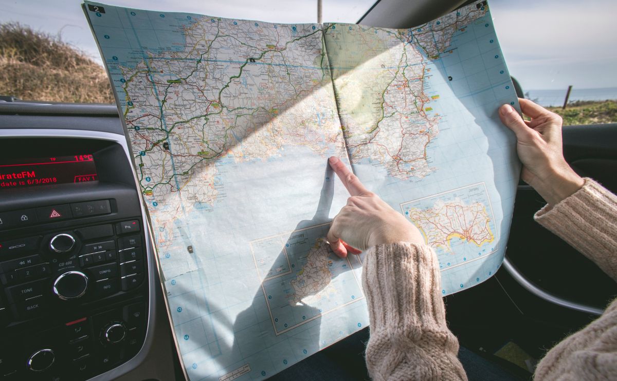 A patient reading a road map in a car, a picture of how far patients are willing to travel to see a doctor