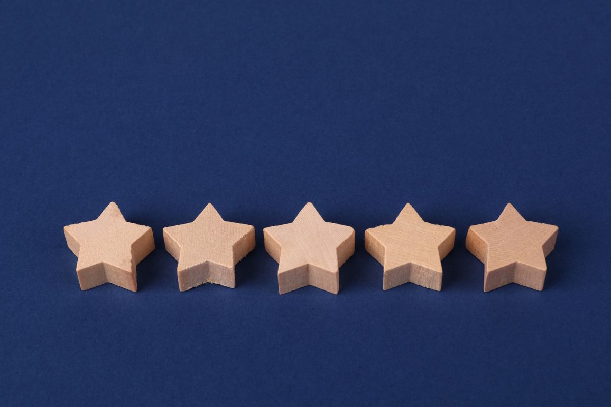 Five star rating symbols on a blue background, representing patient reviews a medical practice should respond to