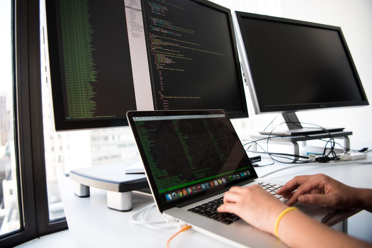 A developer building a medical practice web page on a laptop, deciding how long the page content should be