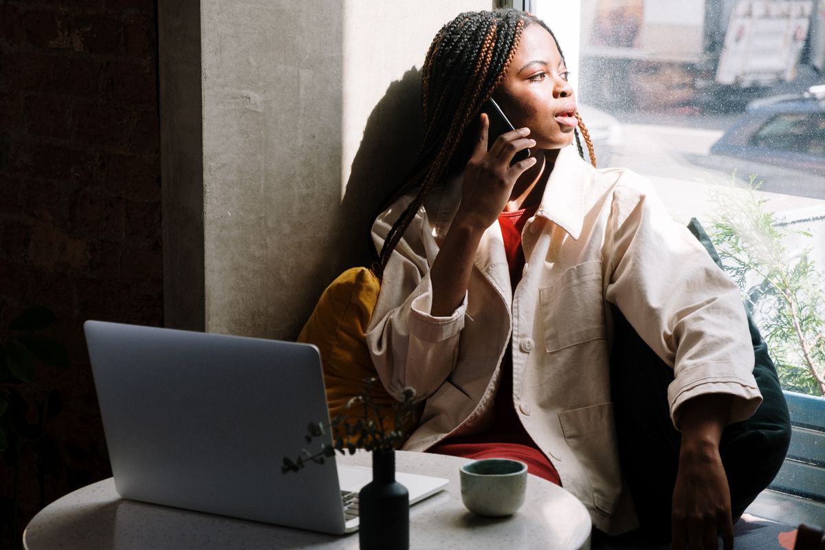 A woman checking her phone while researching a medical practice, the moment patients read your Google reviews before they book