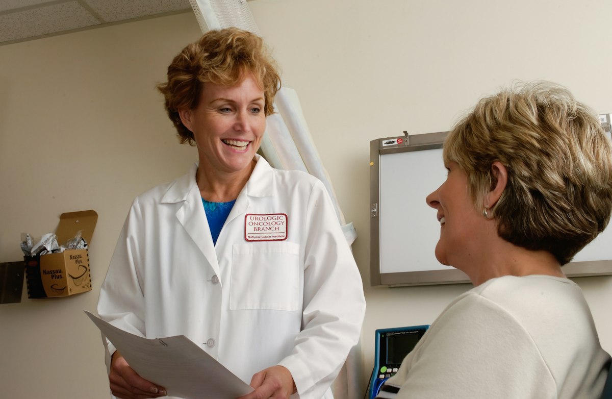 Doctor smiling with a returning patient in a US medical practice exam room