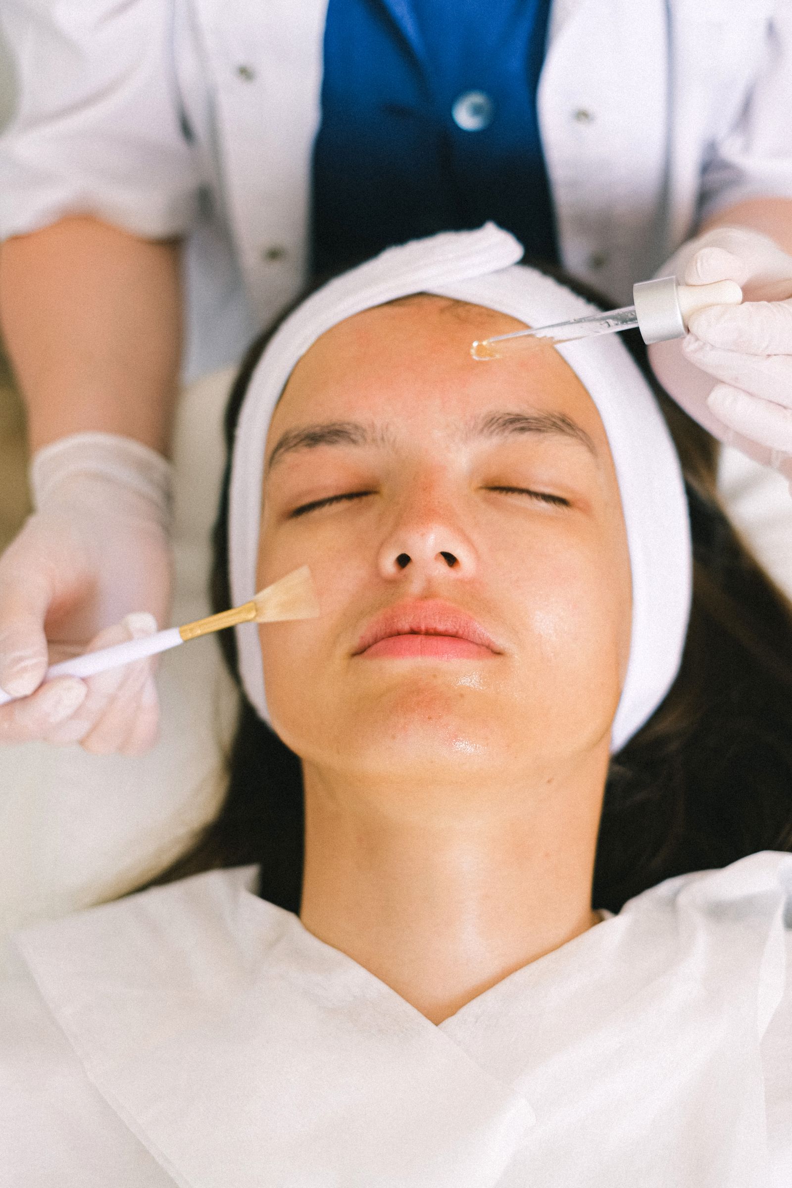 Aesthetician performing a facial treatment on a client at a med spa during the holiday season