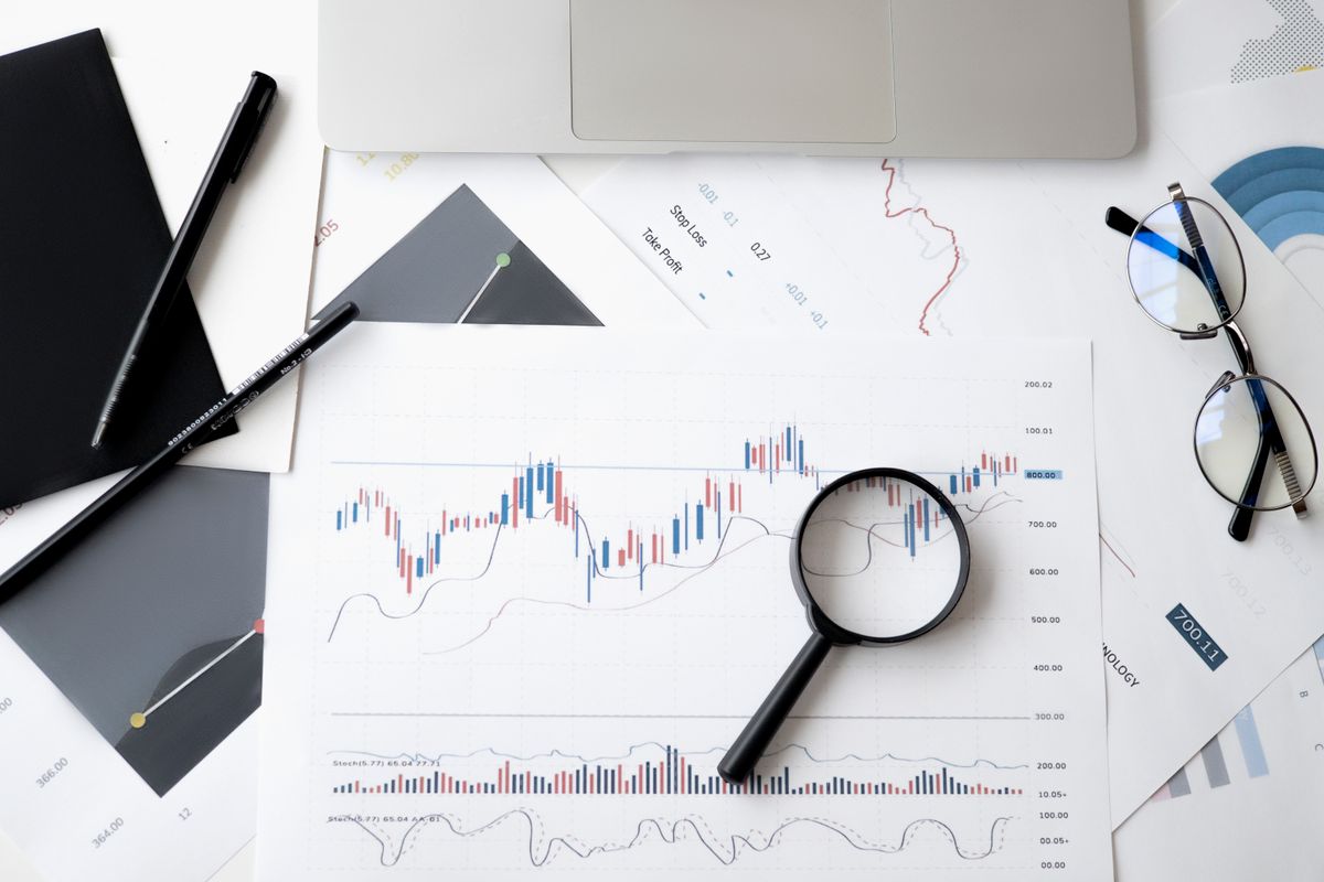 Charts, a calculator and a magnifying glass on a desk, the way a medical practice plans its Google Ads budget