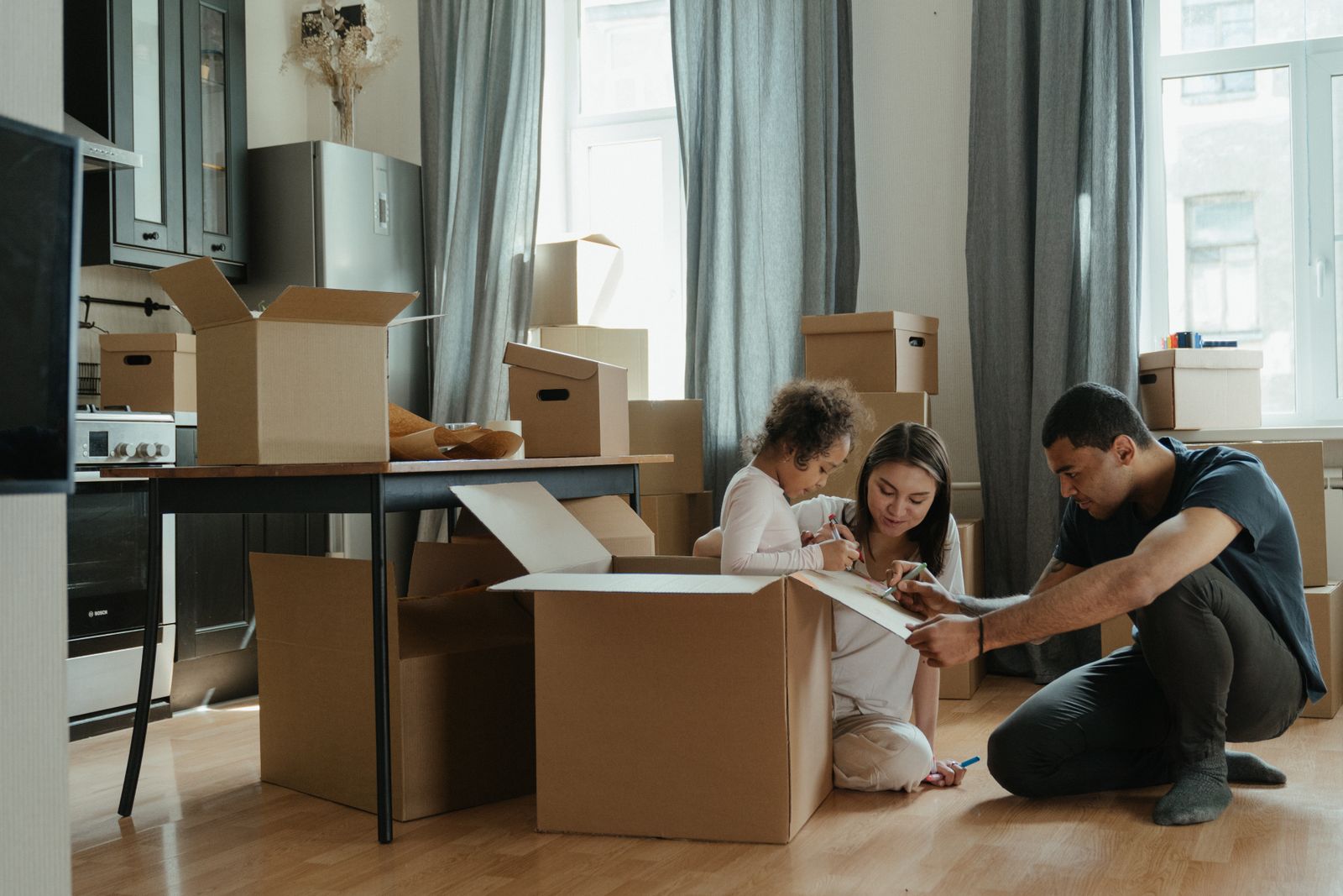 A family unpacking cardboard boxes in a new home, the moment they start searching for a new doctor