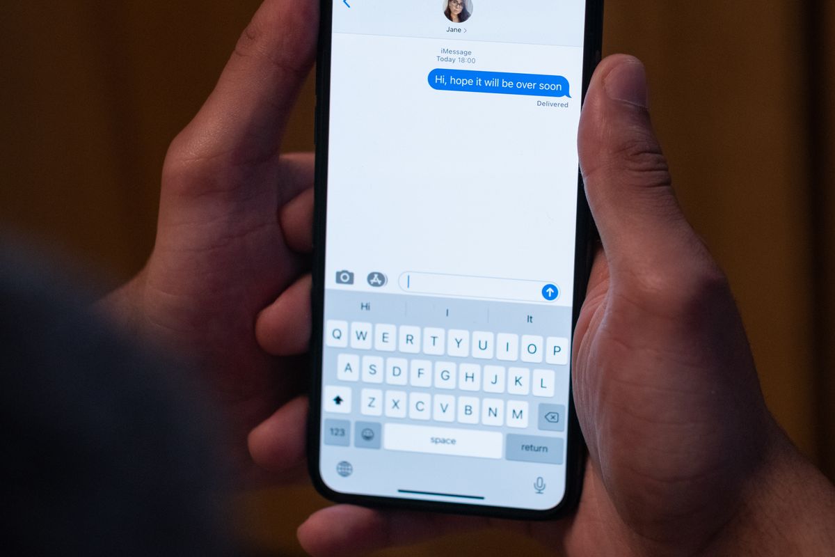 A patient reading a text message from a medical practice on a smartphone, the channel most patients now prefer for appointment reminders