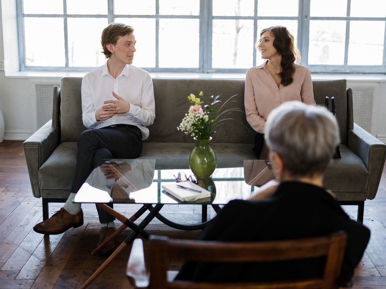 Two people talking warmly while a third listens, the kind of conversation where a patient recommends their doctor to a friend