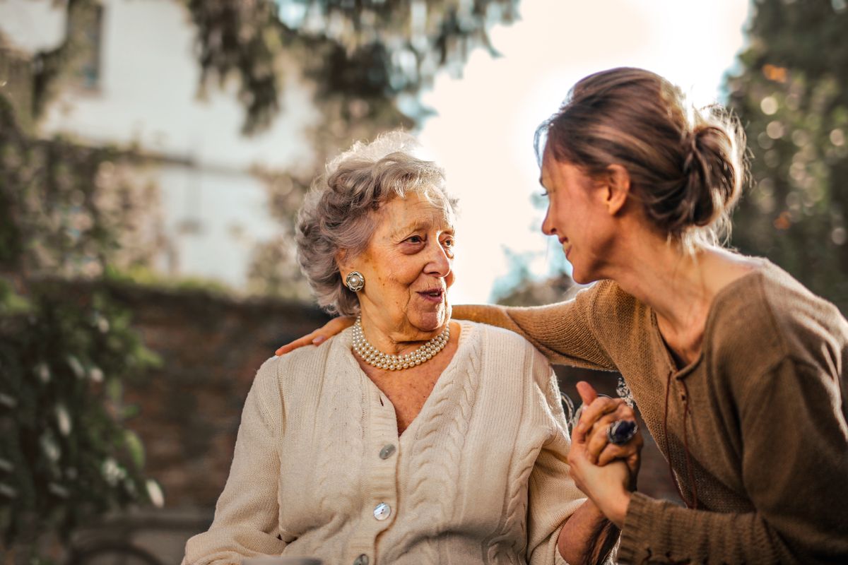 An older woman talking warmly with a younger family member, representing how senior patients choose a medical practice they trust