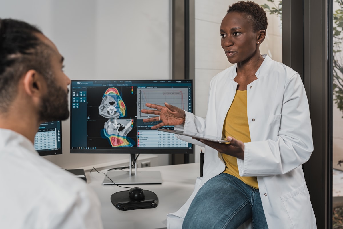A new provider in a white coat talking with a colleague in a modern medical practice with an empty schedule to fill