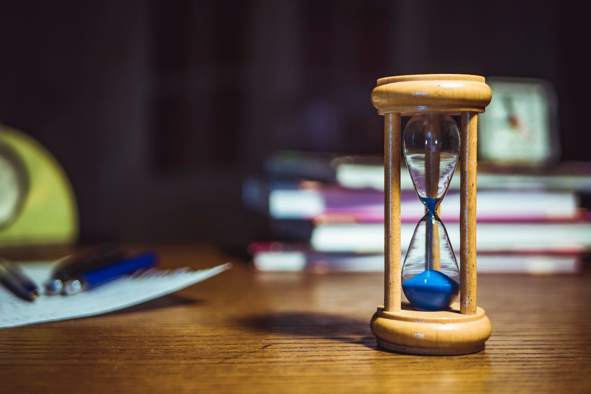 An hourglass running low on a desk, the closing window to fill a last minute appointment cancellation at a medical practice