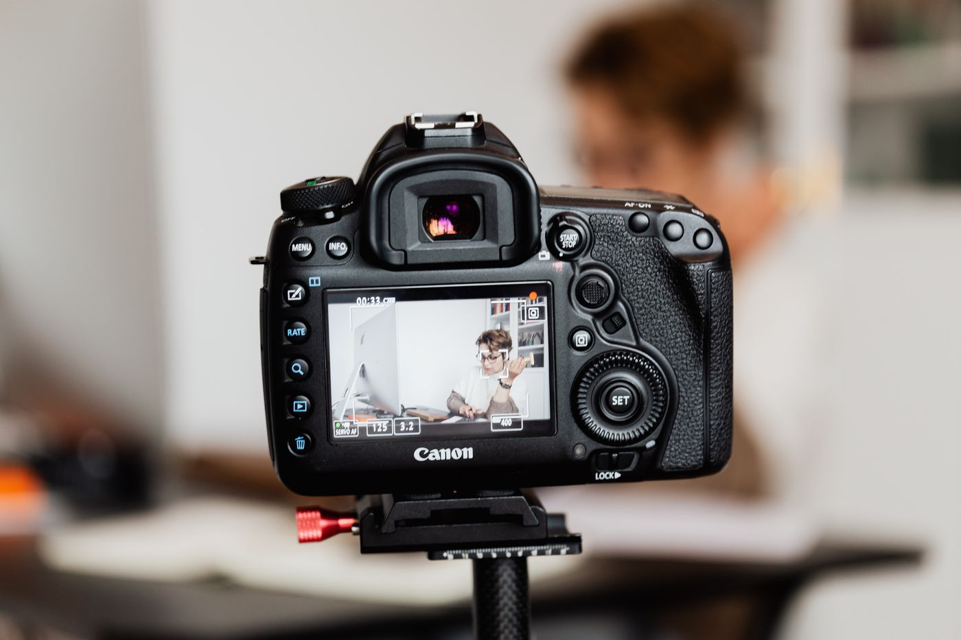 A camera on a tripod recording a person talking, representing a patient video testimonial being filmed at a medical practice