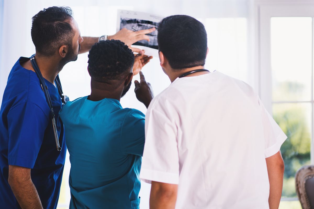 A small team of clinicians reviewing an x ray together in a community medical practice