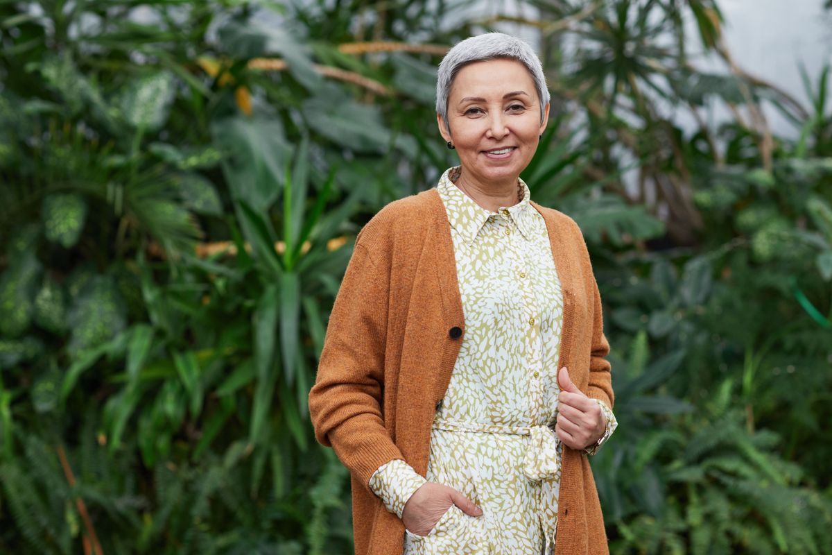 A confident smiling woman in her fifties, the kind of midlife patient a menopause clinic serves