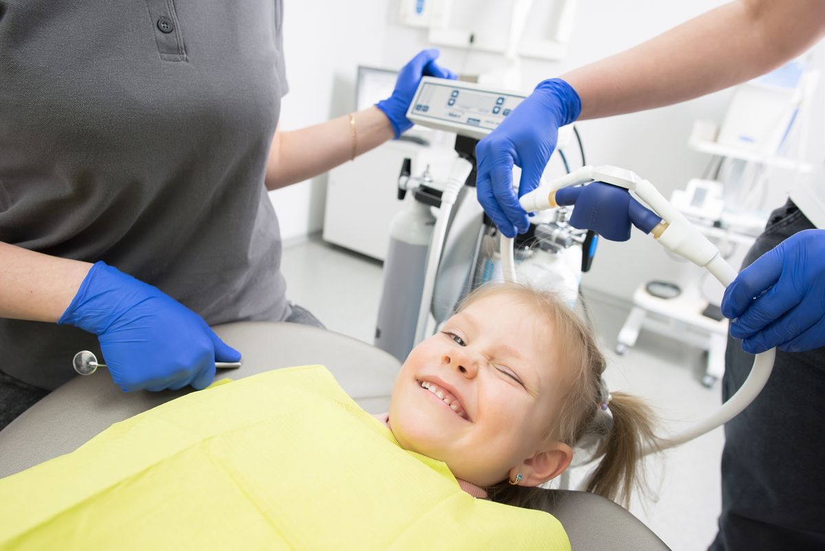 A smiling young girl relaxed in a pediatric dentist chair, the outcome every parent is really shopping for when they choose a kids dentist