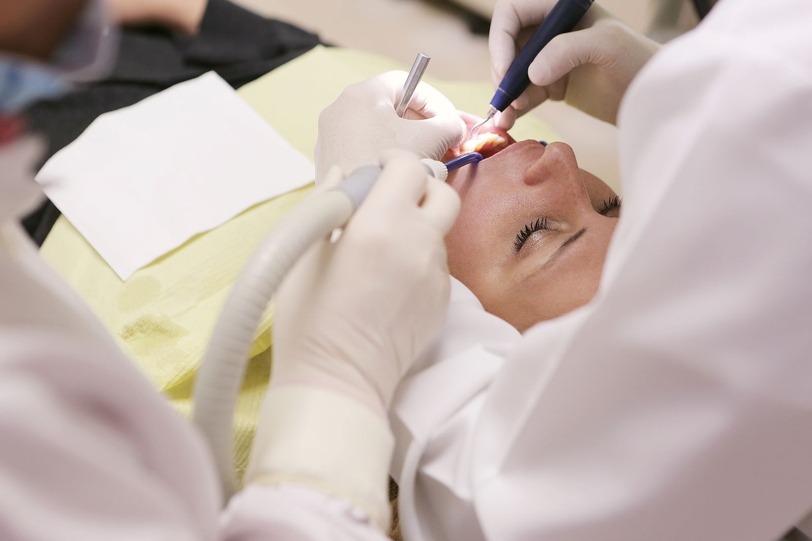 A patient having a periodontal cleaning and gum treatment in a dental chair, illustrating periodontics practice marketing