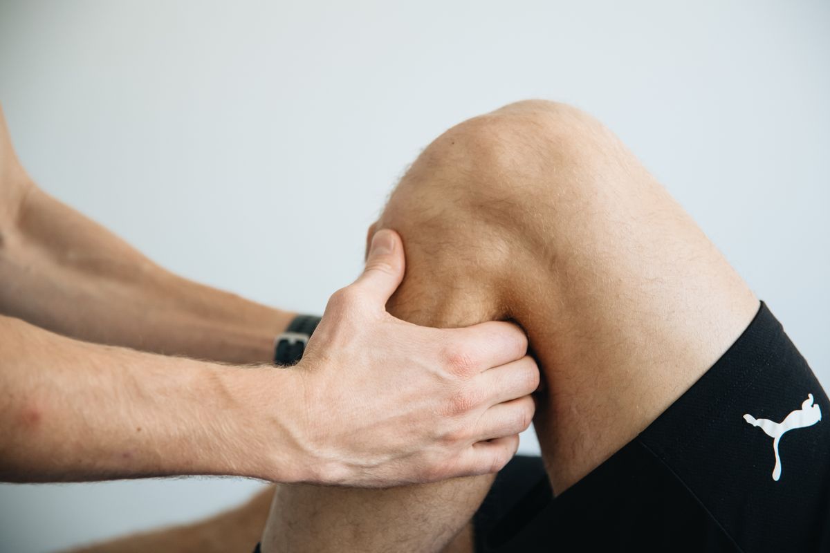 A clinician treating a patient's knee joint in a regenerative medicine clinic