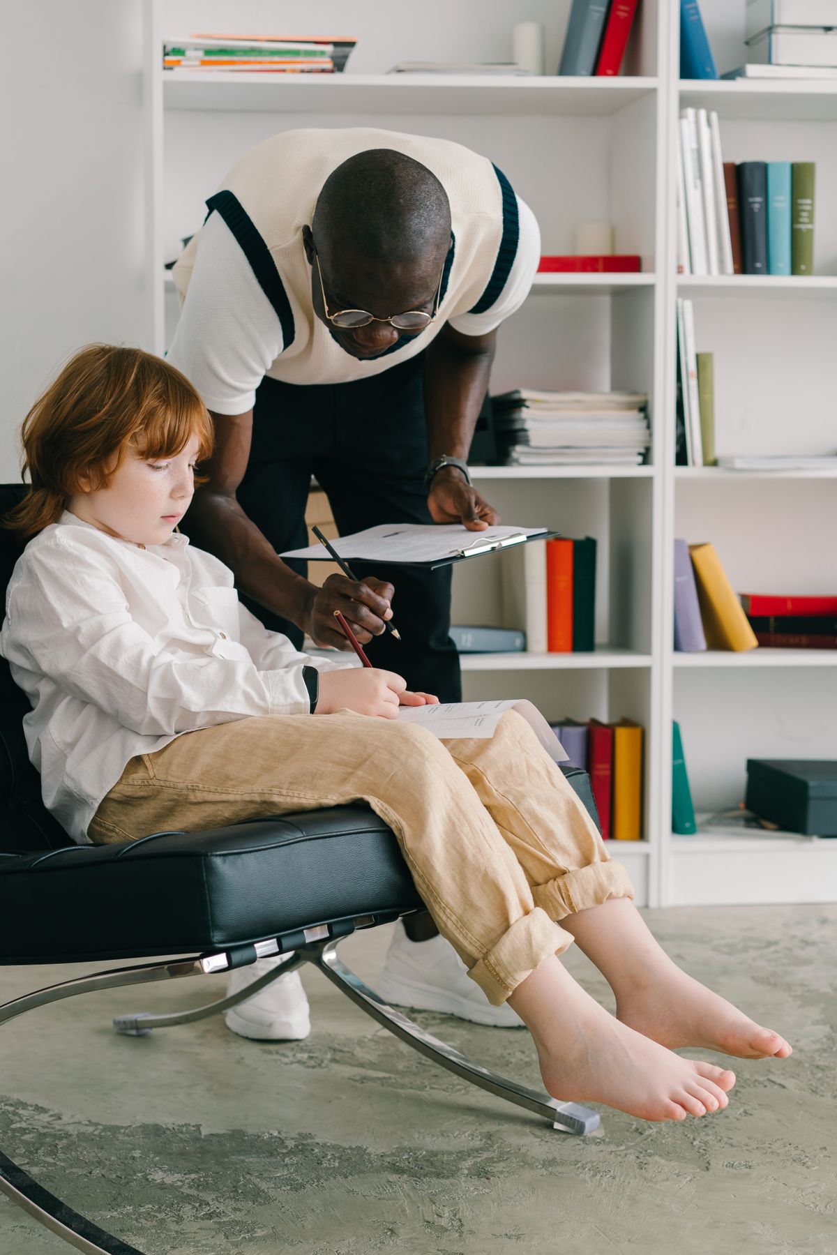 Speech language pathologist working with a young child during a therapy session in a bright office