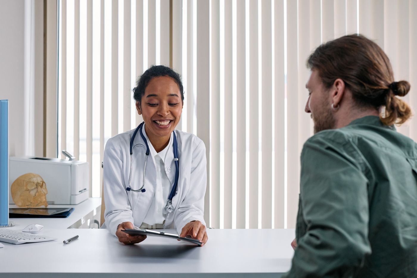 An internal medicine physician reviewing results with an adult patient during an office visit