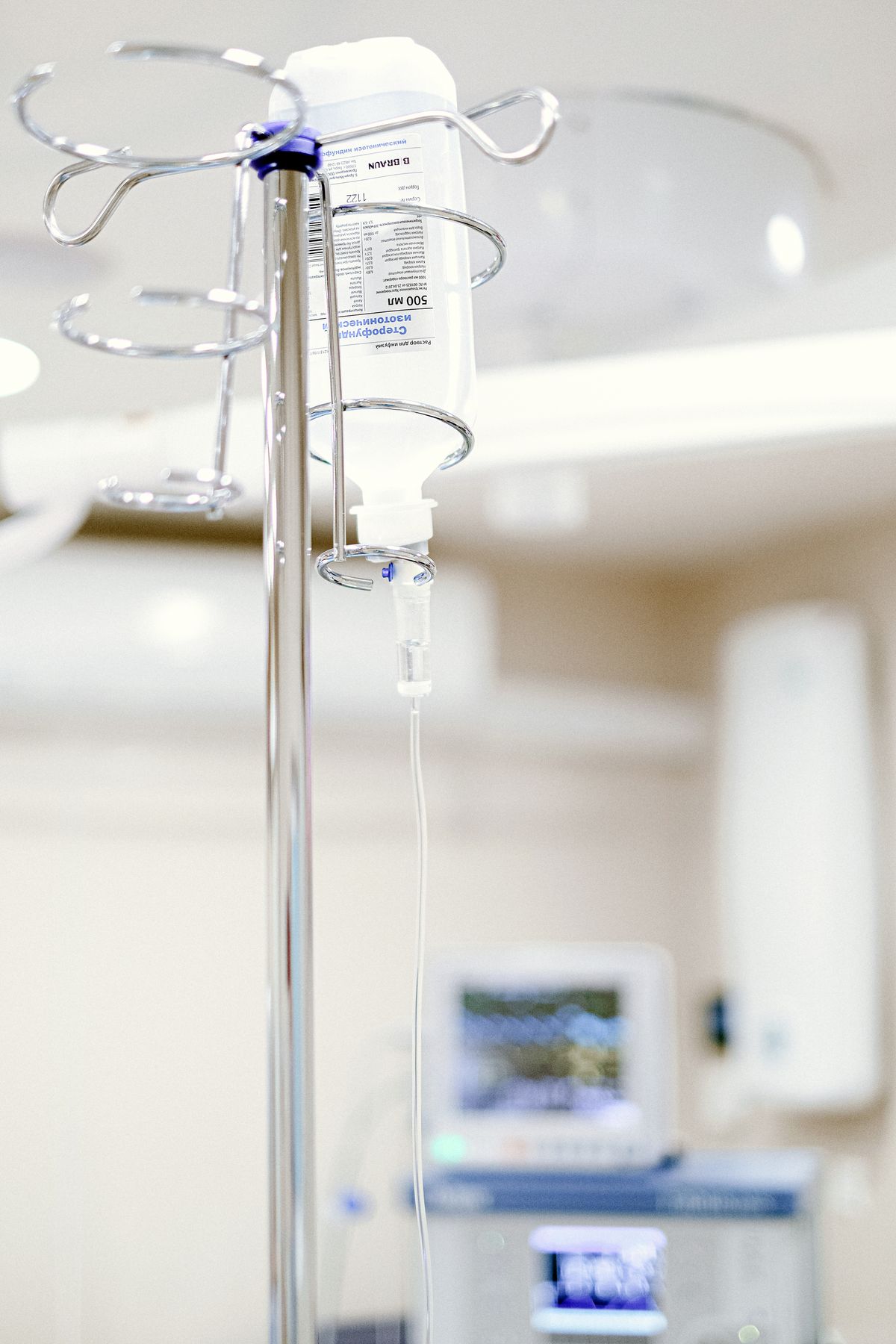 An IV drip bag hanging on a stand in a bright clinic, ready for a patient's infusion