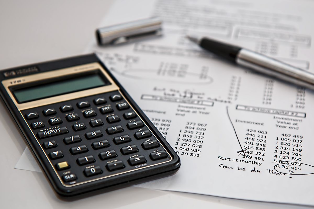 A calculator and notes on a desk, planning how a medical practice should split its marketing budget